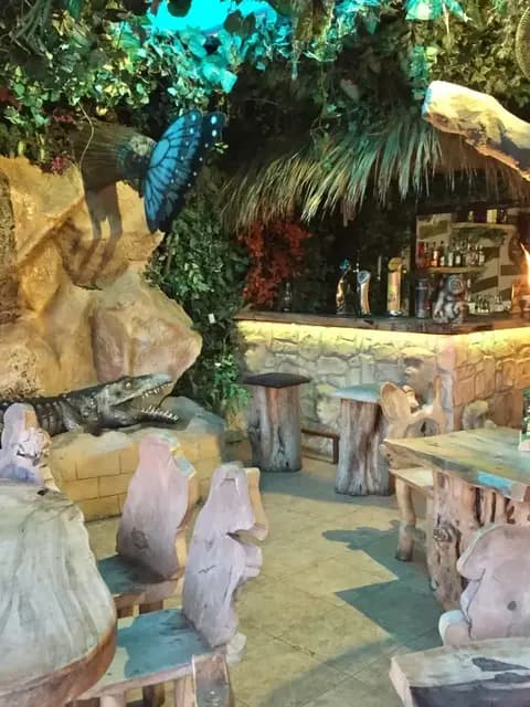 The stone bar at Jungle Mania, framed by carved tree stumps, hanging foliage and a model crocodile